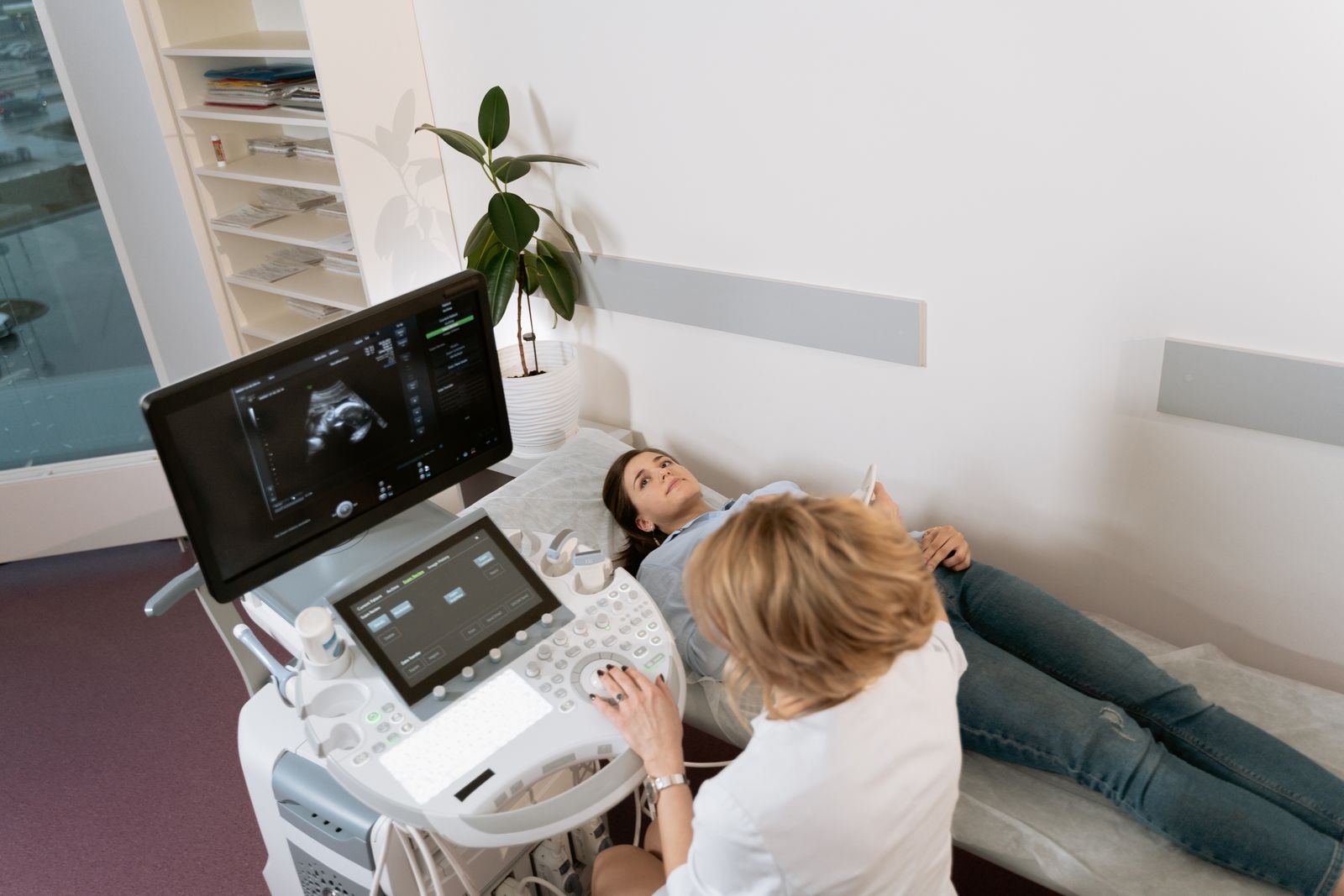 A sonographer at an ultrasound machine with a patient